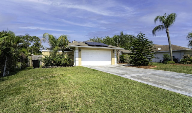 ranch-style house featuring a front yard, roof mounted solar panels, stucco siding, a garage, and driveway