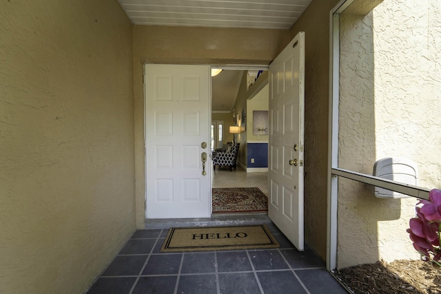 doorway to property featuring stucco siding