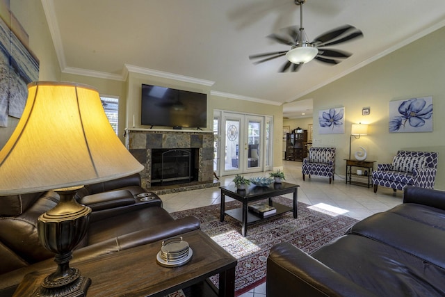 tiled living room featuring baseboards, lofted ceiling, ornamental molding, a glass covered fireplace, and a ceiling fan