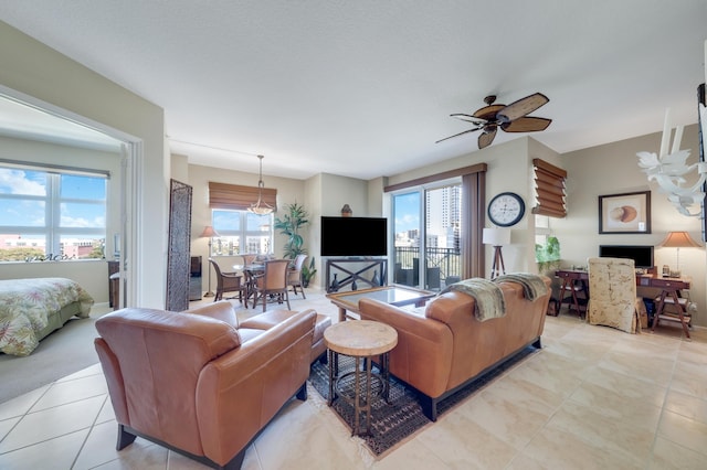 living room featuring light tile patterned flooring and ceiling fan with notable chandelier