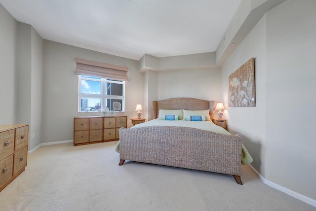 bedroom featuring baseboards and light carpet