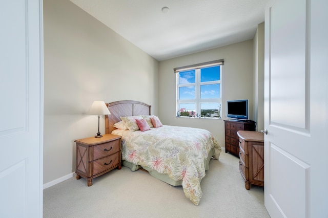 bedroom with baseboards and light colored carpet