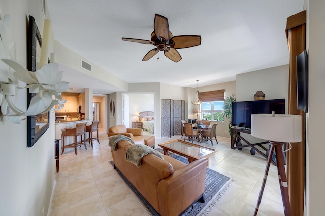 living room with light tile patterned flooring, visible vents, and ceiling fan