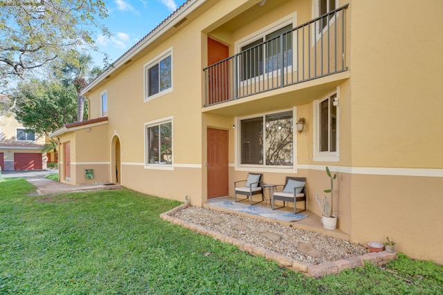500 Scotia Dr Unit 106, Hypoluxo, FL 33462 - rear view of property with stucco siding, a balcony, a yard, and a tiled roof