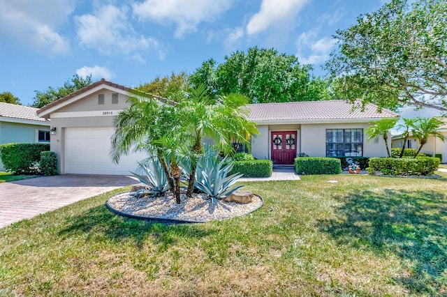 ranch-style home with a front lawn, a tiled roof, french doors, decorative driveway, and a garage