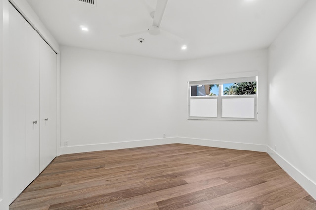 unfurnished bedroom featuring a closet, baseboards, and light wood-style floors