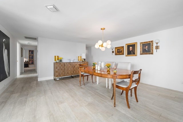 dining area with a notable chandelier, visible vents, light wood-type flooring, and baseboards