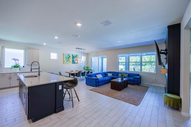 living area with recessed lighting, visible vents, a healthy amount of sunlight, and light wood finished floors