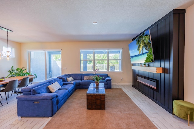 living room with a healthy amount of sunlight, a fireplace, and light wood-type flooring