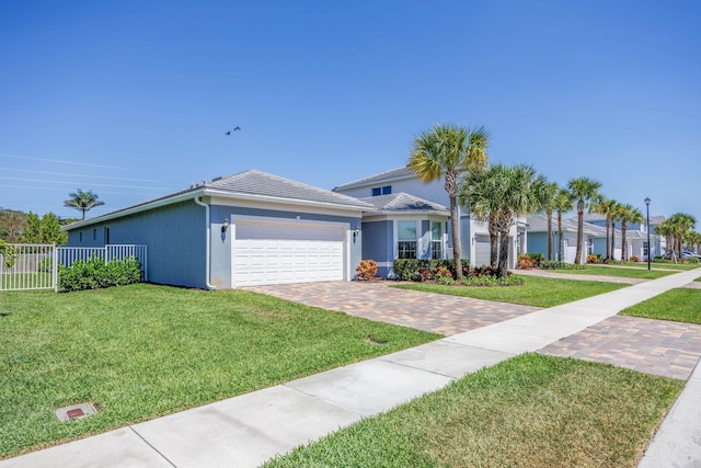 view of front facade featuring fence, stucco siding, a front lawn, a garage, and decorative driveway