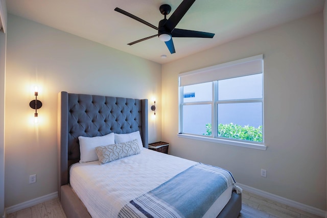 bedroom with ceiling fan, baseboards, and wood finished floors