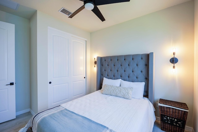 bedroom with ceiling fan, visible vents, baseboards, and wood finished floors