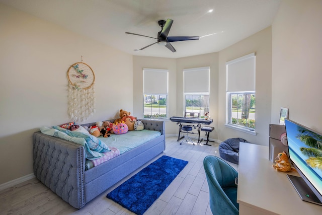 bedroom with multiple windows, baseboards, ceiling fan, and wood finished floors