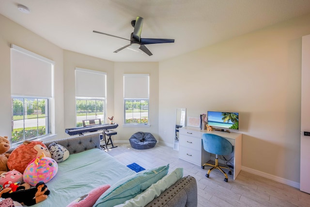 bedroom with a ceiling fan, light wood-style floors, and baseboards