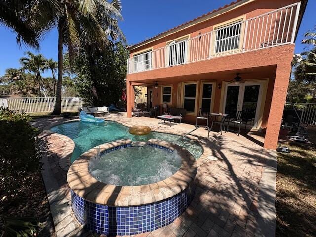 rear view of property with a patio, a fenced backyard, french doors, a balcony, and ceiling fan