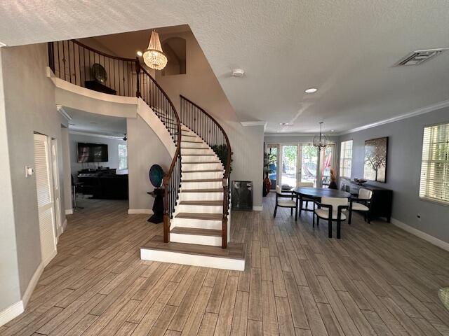 interior space with baseboards, wood finished floors, visible vents, and a chandelier