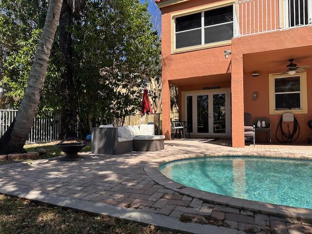 view of pool with a patio area, an outdoor living space, french doors, and fence