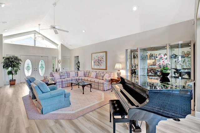 living area featuring high vaulted ceiling, a ceiling fan, and wood finished floors