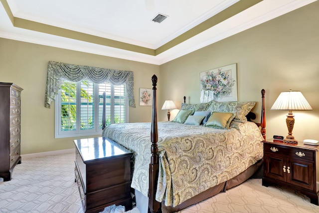 bedroom with visible vents, light colored carpet, a tray ceiling, and ornamental molding