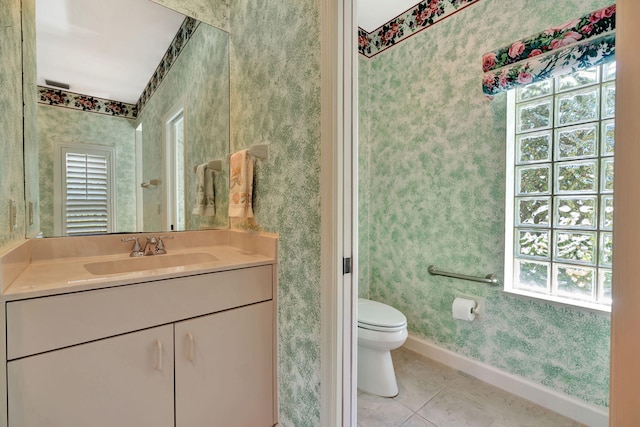 bathroom featuring vanity, baseboards, wallpapered walls, tile patterned floors, and toilet