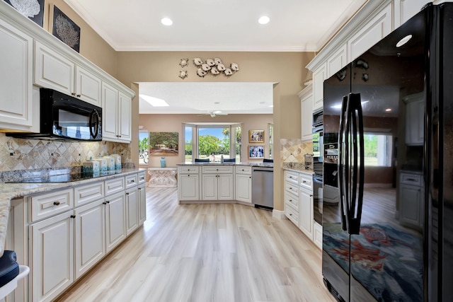 kitchen featuring black appliances, ornamental molding, tasteful backsplash, light wood-style floors, and a peninsula