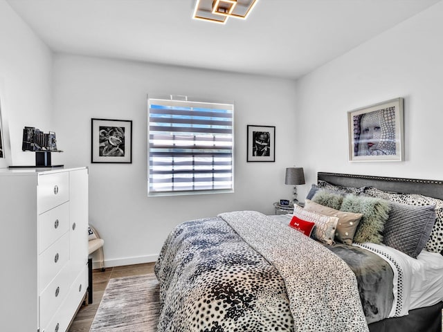 bedroom with baseboards and wood finished floors