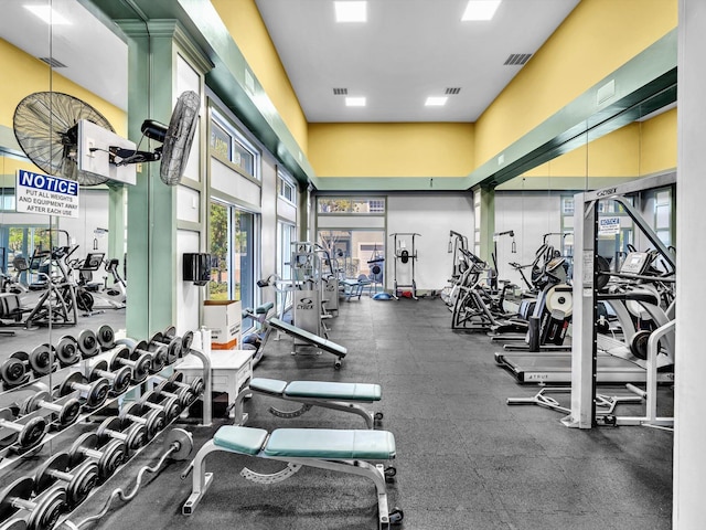 gym with visible vents and a towering ceiling