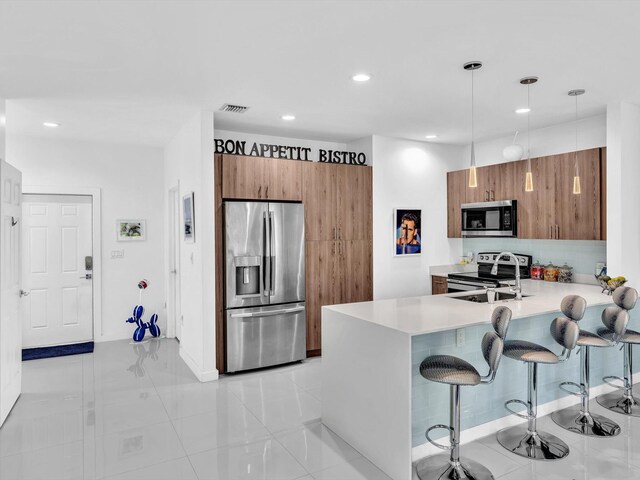 kitchen featuring visible vents, modern cabinets, a sink, stainless steel appliances, and light countertops