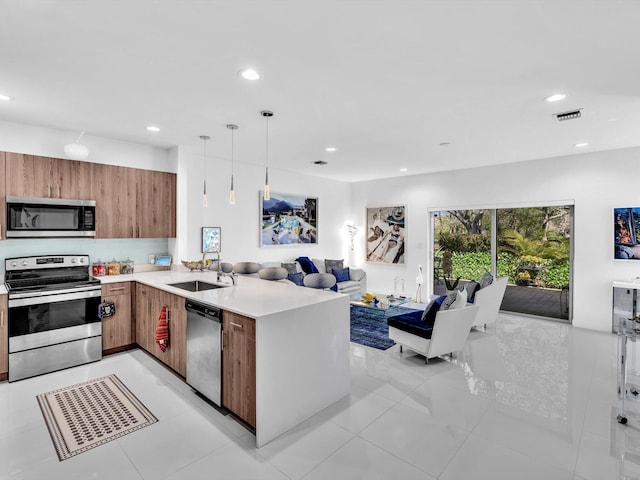 kitchen with visible vents, a sink, stainless steel appliances, light countertops, and open floor plan