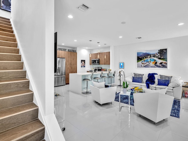 living room featuring recessed lighting, visible vents, baseboards, and stairs