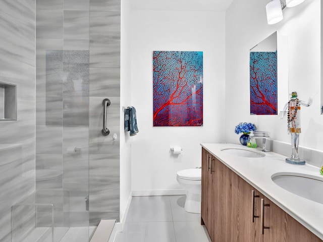 bathroom featuring a shower stall, toilet, double vanity, and a sink