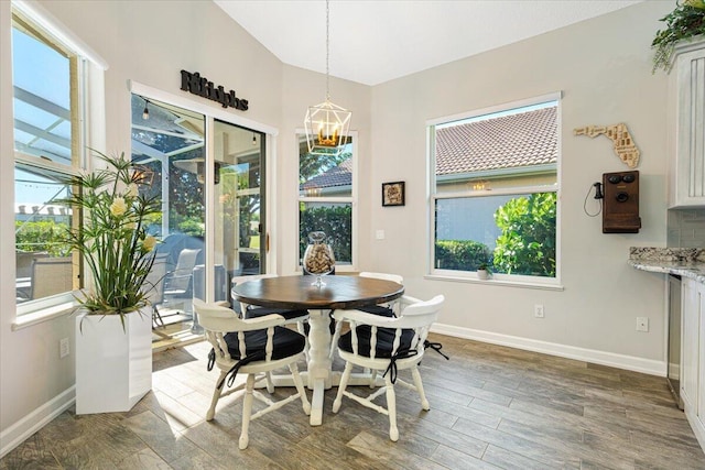 dining area featuring a chandelier, baseboards, and wood finished floors