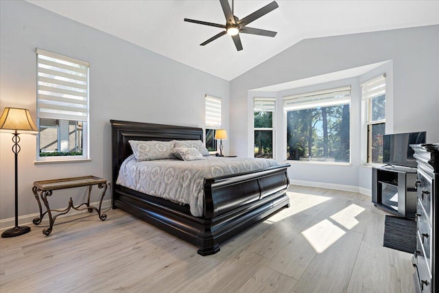 bedroom featuring light wood-style flooring, baseboards, lofted ceiling, and a ceiling fan