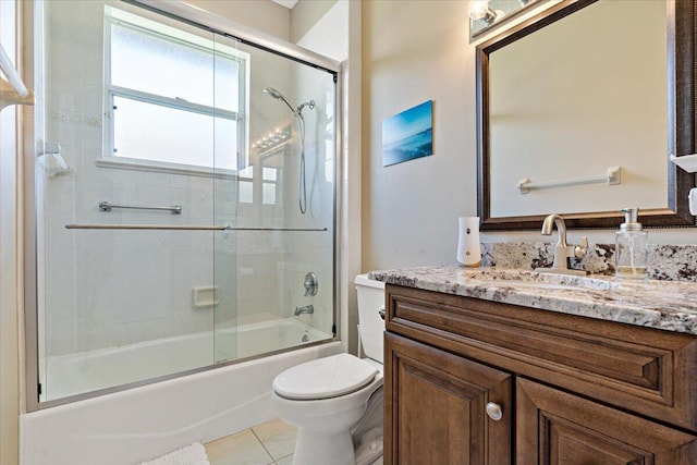 bathroom with vanity, toilet, bath / shower combo with glass door, and tile patterned flooring