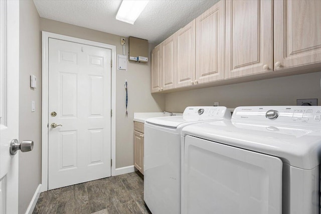 laundry area with washing machine and clothes dryer, baseboards, dark wood-style floors, cabinet space, and a textured ceiling