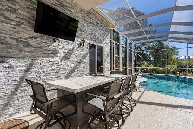 outdoor pool featuring a patio, a lanai, and outdoor dry bar