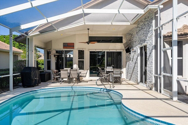 pool featuring glass enclosure, a grill, outdoor dining area, and a patio