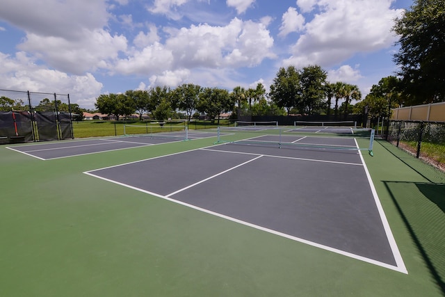 view of tennis court featuring community basketball court and fence