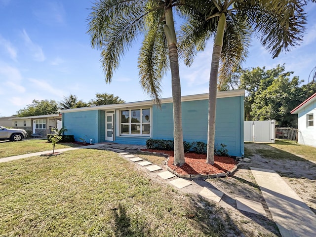 view of front facade with fence, a front yard, and a gate