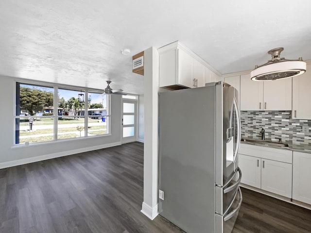 kitchen featuring a sink, backsplash, white cabinetry, and stainless steel fridge with ice dispenser