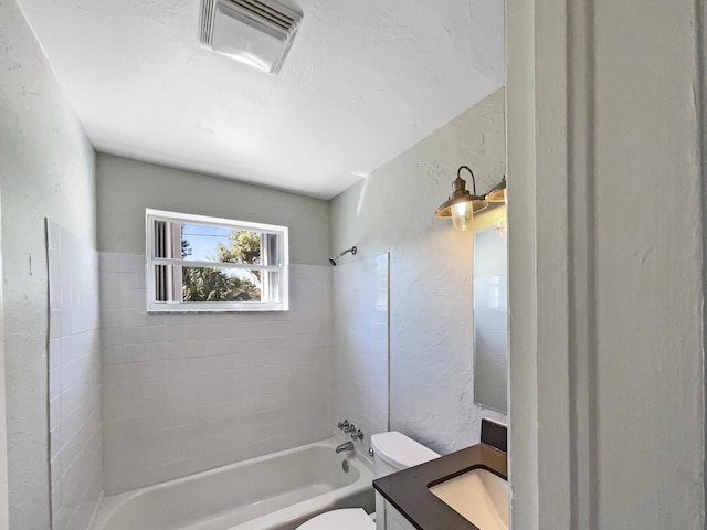 bathroom featuring visible vents, toilet,  shower combination, and a textured wall