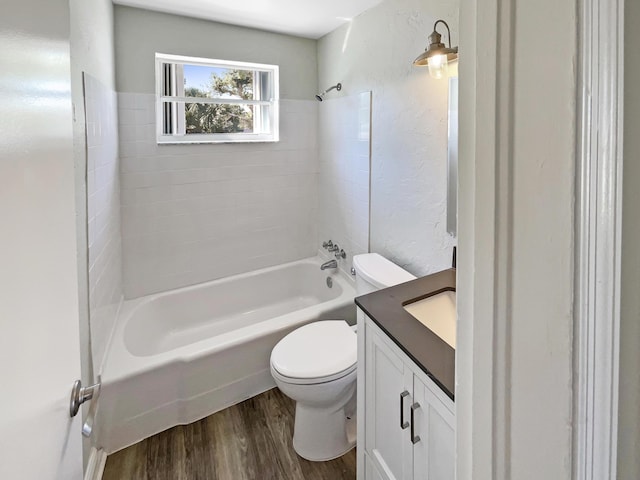 full bathroom featuring toilet, wood finished floors, shower / bathing tub combination, a textured wall, and vanity