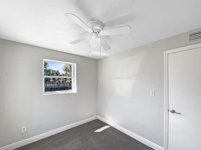 unfurnished room featuring visible vents, baseboards, dark colored carpet, and ceiling fan