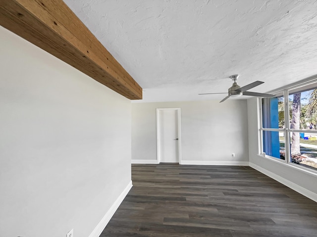 empty room featuring ceiling fan, baseboards, dark wood-style flooring, and a textured ceiling