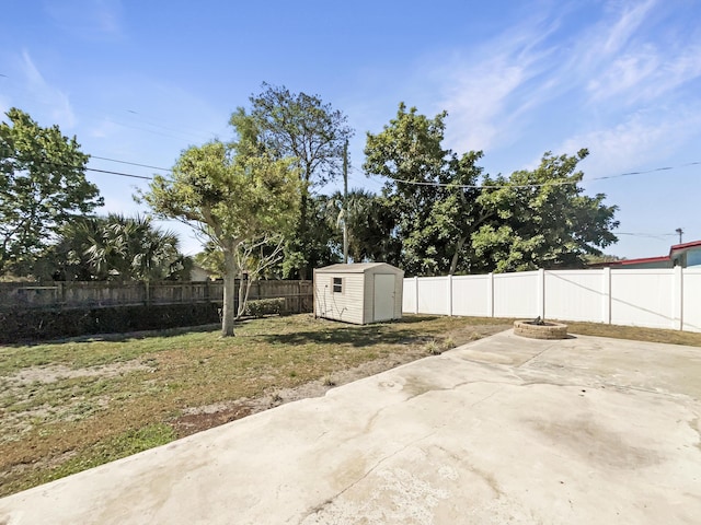 view of yard with a patio area, an outdoor structure, a storage shed, and a fenced backyard