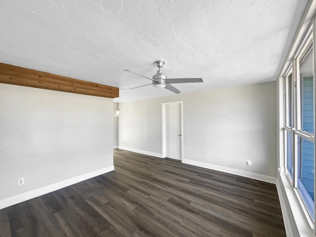 spare room with dark wood finished floors, ceiling fan, a textured ceiling, and baseboards