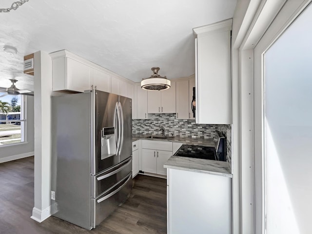 kitchen featuring dark wood finished floors, a sink, electric stove, stainless steel refrigerator with ice dispenser, and tasteful backsplash