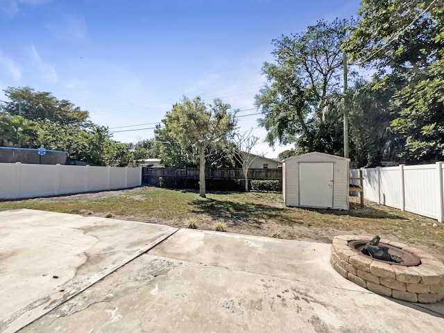 view of yard featuring a storage shed, a patio, a fenced backyard, and an outbuilding