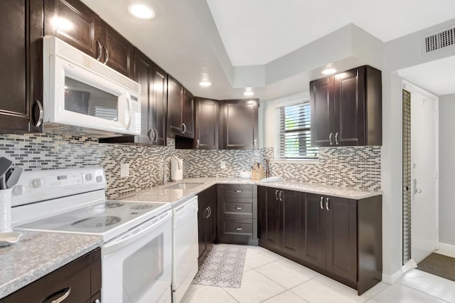 5801 Camino Del Sol Unit 102, Boca Raton, FL 33433 - kitchen with visible vents, a sink, tasteful backsplash, white appliances, and dark brown cabinetry