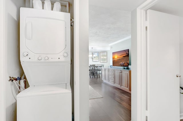 5801 Camino Del Sol Unit 102, Boca Raton, FL 33433 - clothes washing area featuring crown molding, wood finished floors, laundry area, and stacked washer / dryer